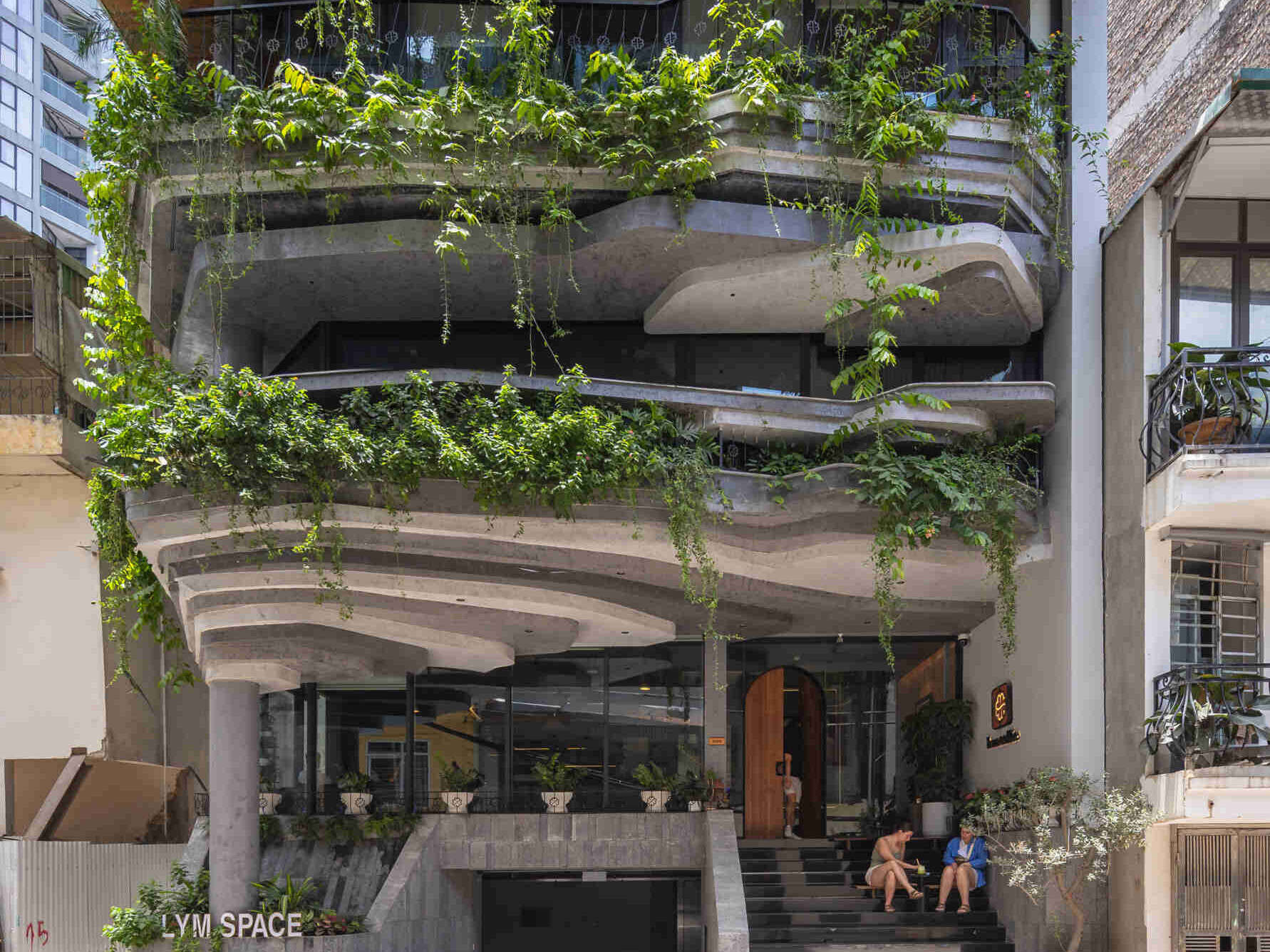 A serene, story-driven building in Hanoi that blends a bold vertical core with soft greenery, natural light, and gentle architectural rhythms to express resilience and quiet elegance in the city.