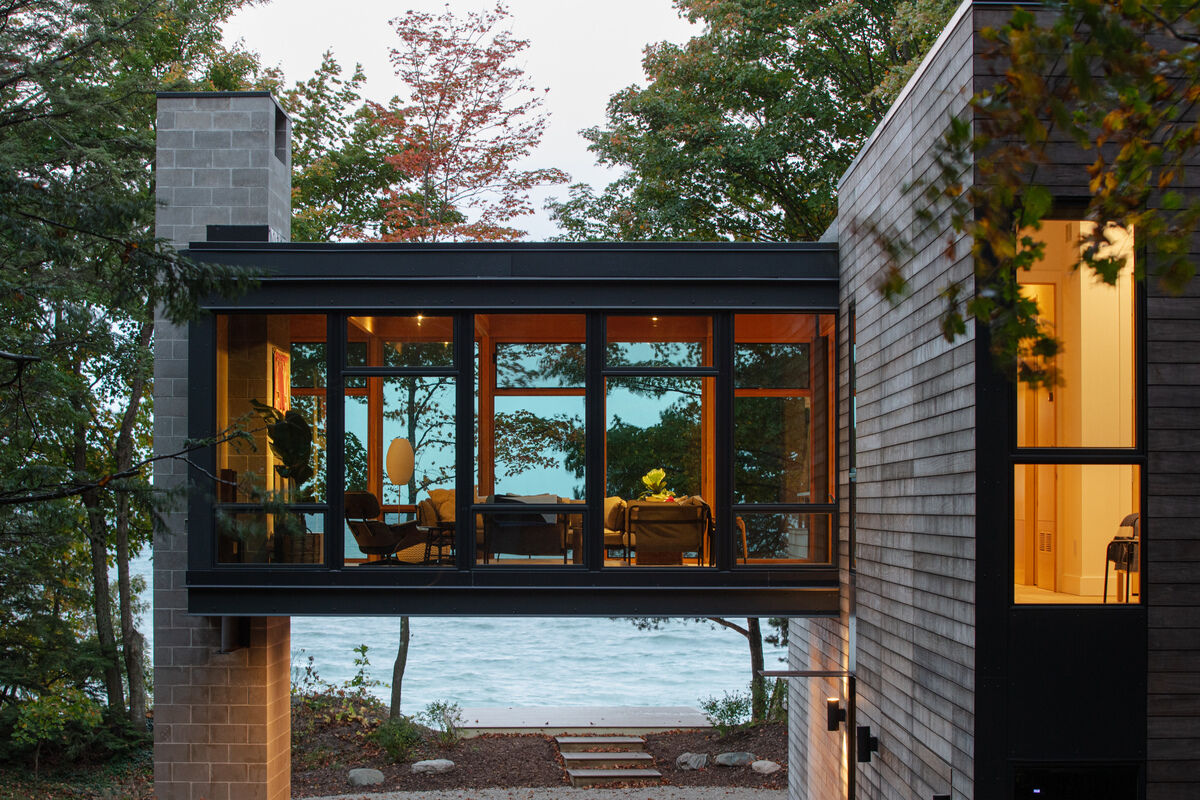 A modern home with a suspended living room opens sightlines through the site while creating sheltered space below